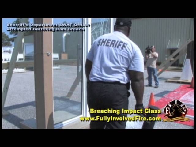 Officer attempting a battering-ram breach of hurricane impact glass